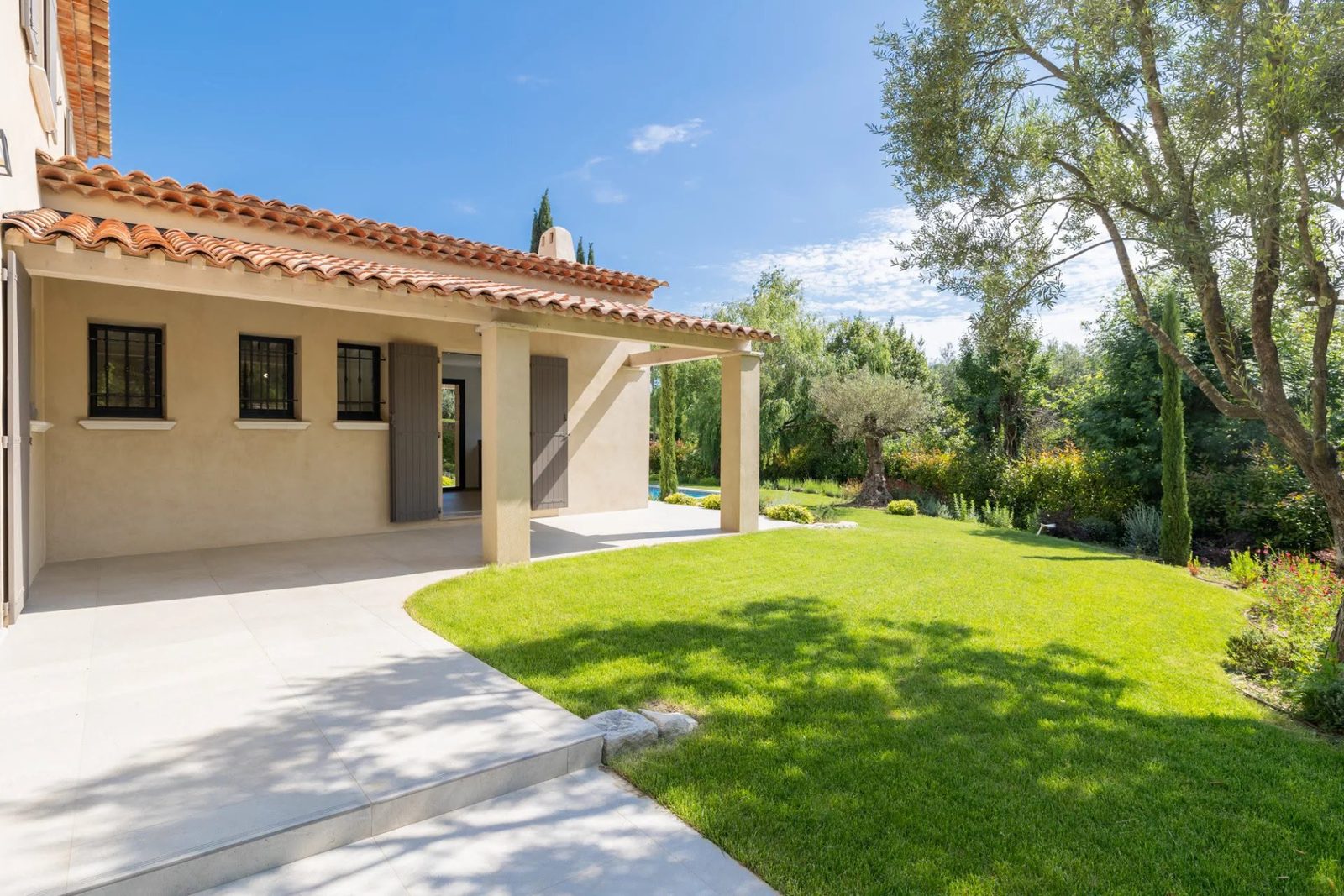 Terrasse couverte et jardin méditerranéen d'une villa sur la Côte d'Azur